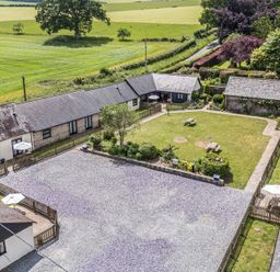 An outdoor area with buildings and a garden at New Barn in Winterborne Stickland