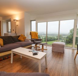 A living room with sofas chairs and a white coffee table overlooking the countryside at Beautiful Cotswold View in Bourton-On-The-Water
