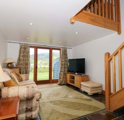 A living room with a sofa and television at Longside in Gilwern