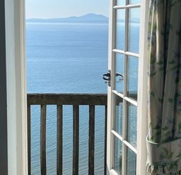 A balcony view overlooking water and mountains at Murmur Y Don in Harlech