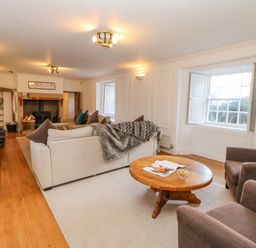 A living room with sofas a coffee table and a fireplace at East Farm House Humshaugh near Hexham