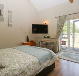 A bedroom with a bed and table at Tawny Owl Barn Shipdham near Dereham