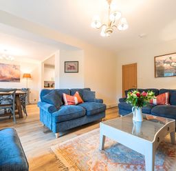 A living room with sofas, a coffee table, and a dining area at Jubilee at the Graythwaite Estate Graythwaite near Hawkshead