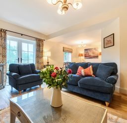 A living room with a sofa, coffee table, and TV at Jubilee at the Graythwaite Estate near Hawkshead