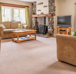 A living room with sofas coffee table fireplace and television at Bassicks Hawkshead