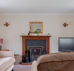 A living room with a fireplace a television and sofas at Hilltop in Graythwaite near Hawkshead