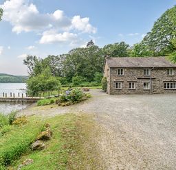 A house by a lake with a dock at Hammerhole at the Graythwaite Estate near Hawkshead