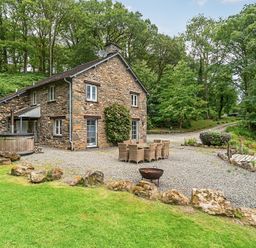 An outdoor area with a house, table and chairs at Hammerhole at the Graythwaite Estate near Hawkshead