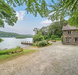 An outdoor view of a lake and a house at Hammerhole at the Graythwaite Estate near Hawkshead