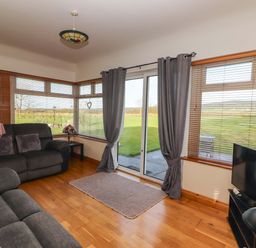 A living room with a sofa and television at Moybella Lodge in Lisselton near Ballybunion, County Kerry