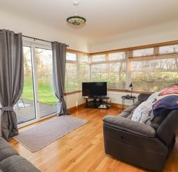 A snug with a television and a sofa at Moybella Lodge, Lisselton near Ballybunion, County Kerry