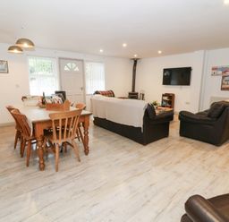 A living room with a table and chairs at Cariad Cottage in Cross Inn