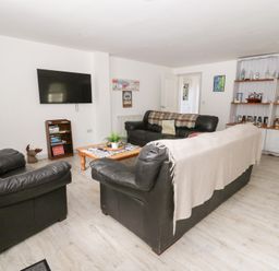 A living room with two sofas and a television at Cariad Cottage in Cross Inn