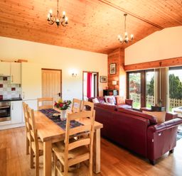A living room with a dining area and kitchen at Sycamore Lodge Nantmel near Rhayader