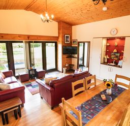 A living room with a dining table and sofa at Sycamore Lodge Nantmel near Rhayader