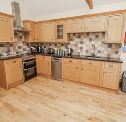 A kitchen with cabinets and appliances at Grey Croft in Embleton