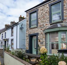 A street view showing stone and painted houses with windows and gardens at Rose Cottage in St Dogmaels near Cardigan