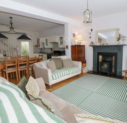 A living room with a sofa and dining table at Rose Cottage in St Dogmaels near Cardigan