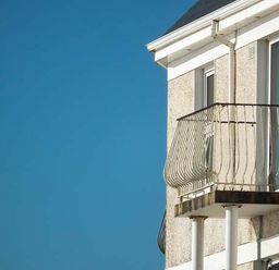 A section of a building with two small balconies and a clear blue sky at The Beach House Apartment in Buncrana County Donegal