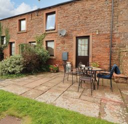 An outdoor patio area with a table and chairs at Stable Cottage Bolton Low Houses