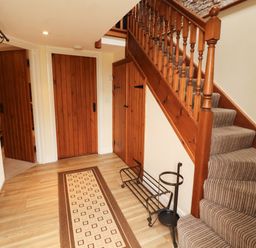 A hallway with a staircase and doors at Stable Cottage in Bolton Low Houses