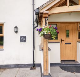 An entrance with a wooden door and window at Ty Gwyn in Llangwm near Bala