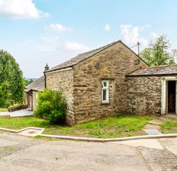 An outdoor area with a stone building and pathway at Dove Cottage at the Graythwaite Estate near Hawkshead