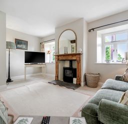 A living room with a television and fireplace at Dove Cottage at the Graythwaite Estate near Hawkshead
