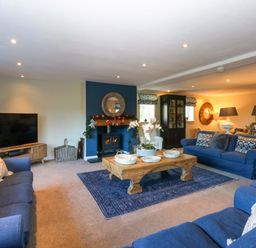 A living room with a television and fireplace at Nant-yr-Rhedyn in Red Wharf Bay