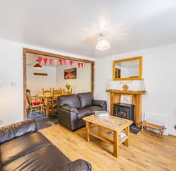 A living room with leather sofas and a wood coffee table next to a dining area at No 7 Spark Bridge near Ulverston