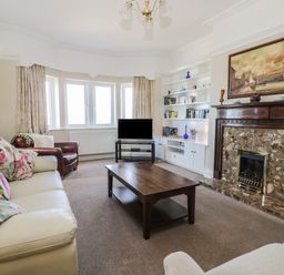 A living room with sofas a wooden coffee table and a fireplace at Seascape in Bridlington