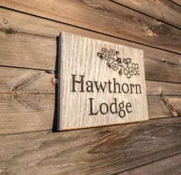 A wooden sign with the text Hawthorn Lodge mounted on a wooden wall at Hawthorne Lodge in Liverton near Danby