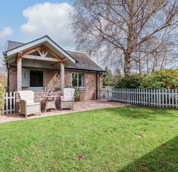 A house with a white fence and chairs in the front yard at The Lodge, Lower Trefedw in Pandy near Abergavenny