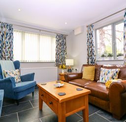 A living room with a sofa and armchair at The Lodge, Lower Trefedw, Pandy near Abergavenny