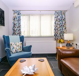 A living room with armchairs and a coffee table at The Lodge, Lower Trefedw, Pandy near Abergavenny