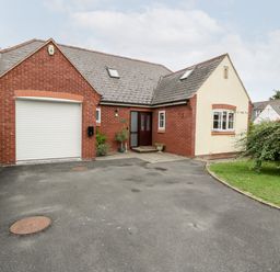 A brick and stucco house with a garage and driveway and a small garden at Hurst Green in Ewyas Harold near Hereford