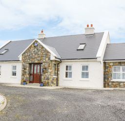 Exterior view of a single-story house with stone and white walls and a gray roof at McGuire's Cottage Barnatra County Mayo