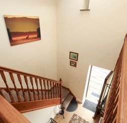 A staircase with artwork on the wall at Hayloft Cottage in Bolton Low Houses