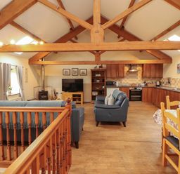 A living room with a kitchen area and seating at Hayloft Cottage Bolton Low Houses