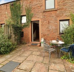 An outdoor area with a table and chairs at Horseshoe Cottage in Bolton Low Houses