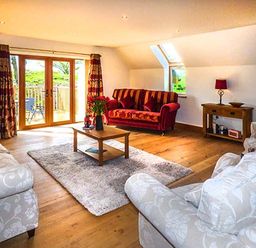 A living room with sofas coffee table and a sideboard at Brynhir Farm in Howey near Llandrindod Wells