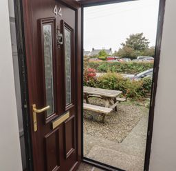 An entrance with a door and a bench outside at Garth Cottage Haverfordwest