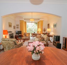 A living room with sofa chairs a wooden table and flowers in a vase at West Ridge in Boscombe