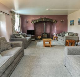 A living room with a fireplace and sofas at Glan y Gors in Dinorwic near Llanberis