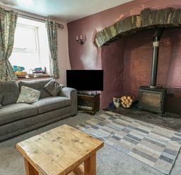 A living room with a sofa and coffee table at Glan y Gors in Dinorwic near Llanberis