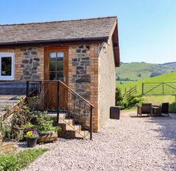 An outdoor area with steps leading to a door at Peniarth in Penybontfawr near Oswestry