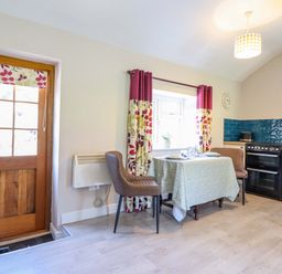 A kitchen with a table and chairs at Peniarth in Penybontfawr near Oswestry