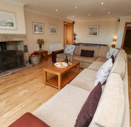 A living room with a sofa and coffee table at Granary Stone House Embleton