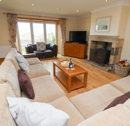 A living room with a sofa and coffee table at Granary Stone House in Embleton