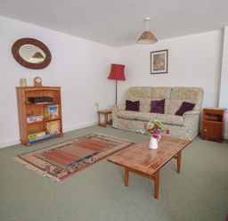 A living room with a sofa and bookshelf at West Bowden Farm in Knowstone near South Molton